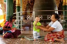 Dieses Foto entstand am 21.11.2012 auf einer Reise durch Myanmar in der Shwedagon-Pagode in Yangon. In einem Tazaung, einer Andachtshalle, in der die berühmte Maha-Ganda-Glocke hängt, erlebte ich eine berührende Familienidylle: Während die junge Mutter ihr Baby stillte, unterstützte die Oma das Brüderchen bei seinen Gehversuchen. Dass die Mutter ihr Baby in einem sakralen Raum stillt, scheint ganz selbstverständlich zu sein. Mit Augen und Gesten nahmen wir Kontakt auf - ich war fünf Monate zuvor selbst zum ersten Mal Großmutter geworden.